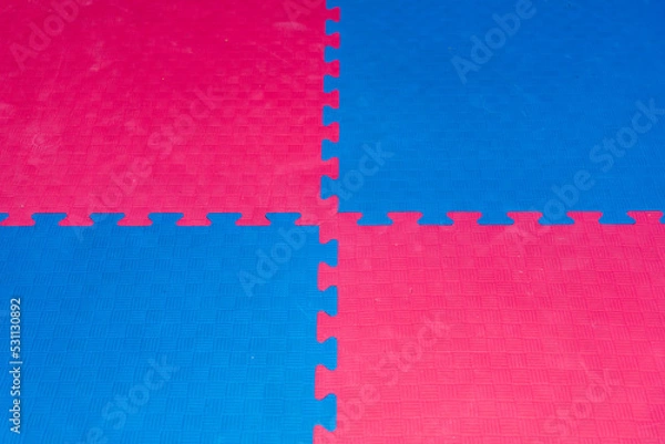 Fototapeta Eva foam rubber floor puzzle mats texture, colorful floor mat background. Multicolored soft elements. Blue and pink puzzles connected