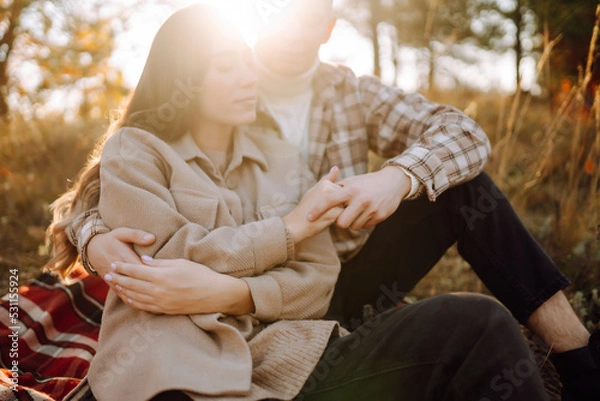 Fototapeta Young couple in love walking in the park on a autumn day. Enjoying time together.