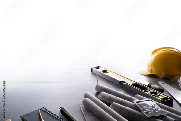 Fototapeta Contractor theme. Plans,  notebook and tool kit of the contractor: yellow hardhat, libella, saw and yardstick  on the gray tiles background.