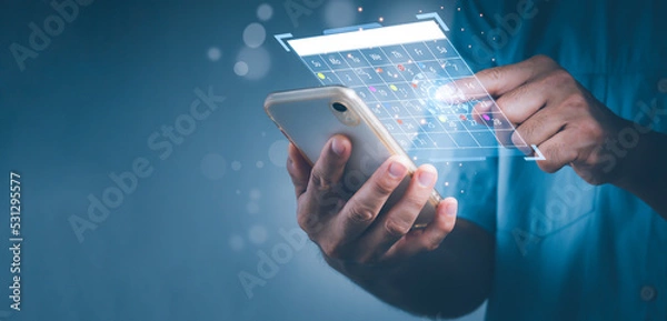 Fototapeta A man His right phone displayed Appointment Reminder for the Calendar as well as the Organizer's Agenda. Timetables are used by event planners to arrange events.