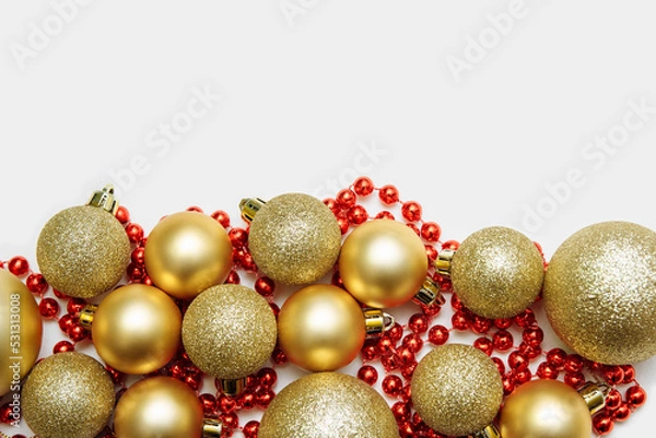 Fototapeta Christmas decorations golden balls and red garland on a white isolated background close-up ,flat lay, with an empty space for text, copy space, greeting card concept, ad design template
