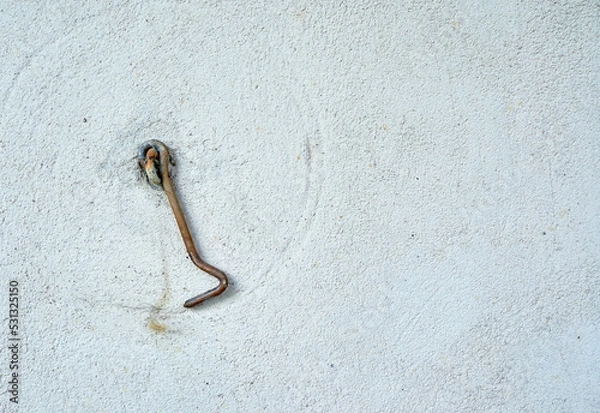 Fototapeta Metal old hook on wall of house with empty space for insertion.