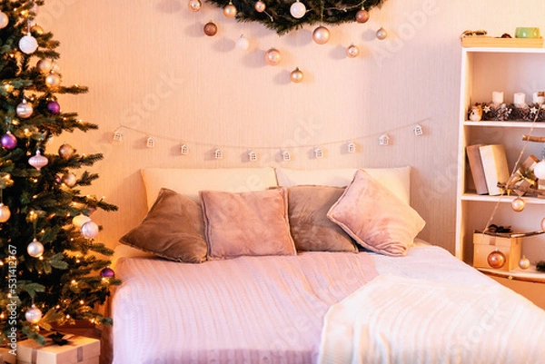 Fototapeta festive decoration of the bedroom by Christmas: balls in a wooden box, sculpture of deers, candles in a glass lantern, garland, handmade triangular pendant composition in the form of a tree with star