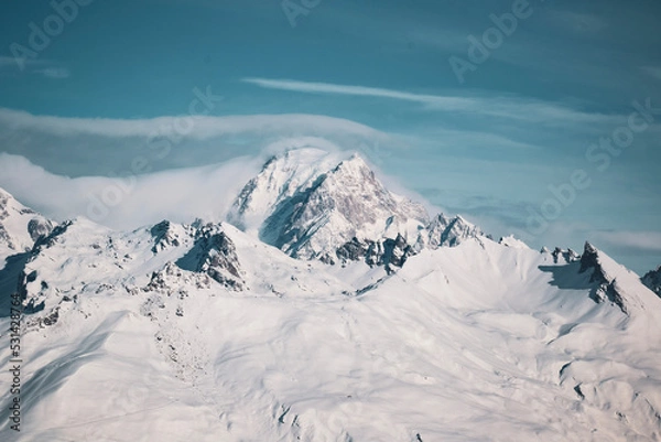 Fototapeta Mont-Blanc covered in snow overflown by a cloud