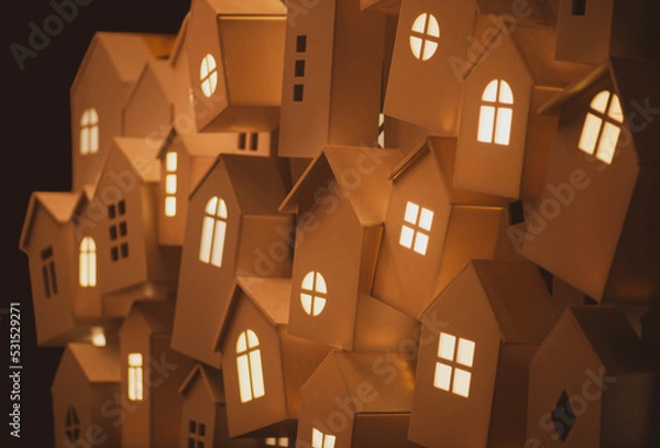 Obraz light from the windows of small decorative, white houses on the street of a European city during the winter seasonal holidays