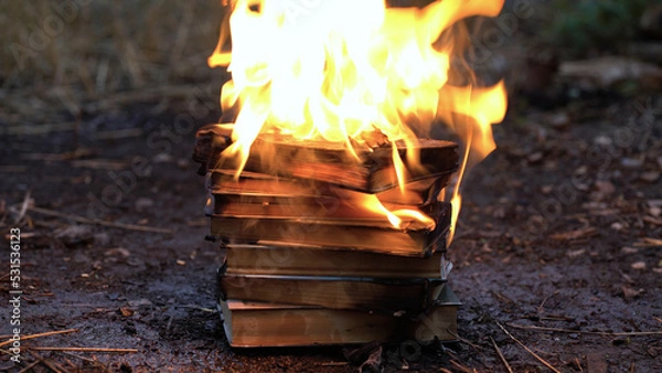 Obraz A stack of old books on fire burns on the ground