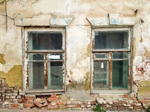 Fototapeta Windows in an old crumbling house.