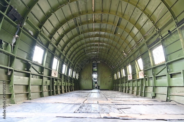 Fototapeta Fuselage of the inside of a military green plane during the war era showing the empty space that troops were carried in. Paratroopers would jump from this plane and sky dive to the ground
