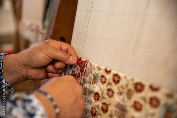 Fototapeta Carpet weaving using traditional techniques on a loom. , close-up of weaving and handmade carpet production.