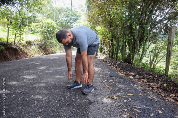 Fototapeta Normal weight man toe touches to Warm Up for a Workout