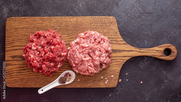 Obraz Two Different Balls Of Minced Meat: Beef And Pork Got Placed On A Wooden Board Separately. Culinary Preparation. Hamburger Ingredients. Peppercorns, Coarse Tibetan Salt, Nutmeg. View Above.