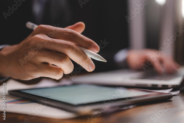 Fototapeta business communication technology concept, businessman person using digital pen to working on tablet computer screen device in modern office workplace, online marketing document on desk table