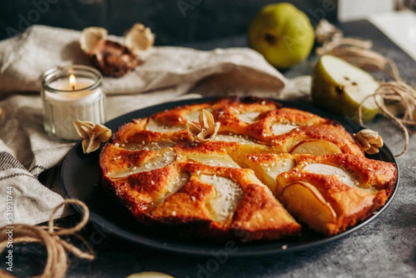 Fototapeta Cake with pear, honey and almonds. Delicious pie on a concrete table