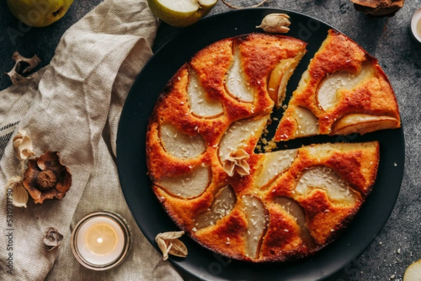 Fototapeta Cake with pear, honey and almonds. Delicious pie on a concrete table