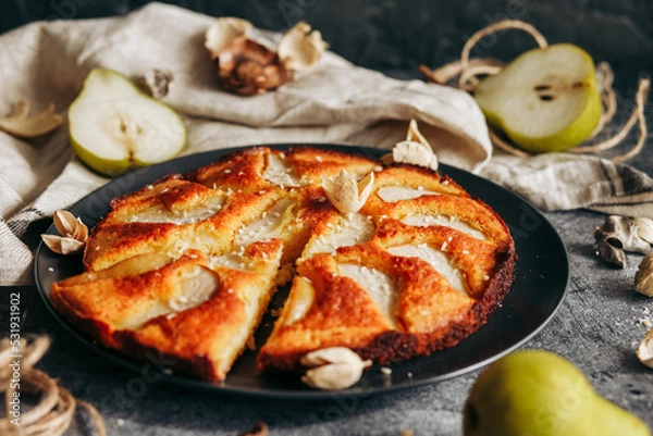 Fototapeta Cake with pear, honey and almonds. Delicious pie on a concrete table