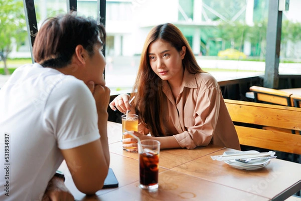 Obraz Asian woman feeling shy her boyfriends, in love, smiling when eating lunch together at restaurant.