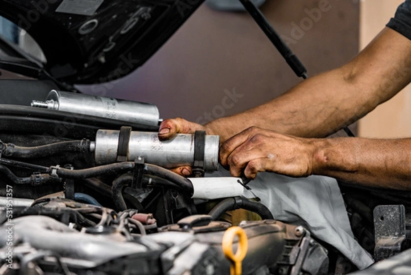 Obraz Close up of auto mechanic repairing car engine in car service
