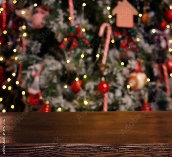 Fototapeta Christmas background. Empty wooden table on the background of the Christmas tree and New Year's bokeh.Ready for product montage. Banner.Mockup.