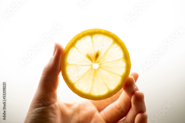 Fototapeta round slice of lemon in hand