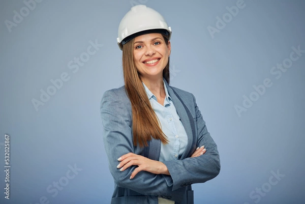 Obraz Smiling woman architect or engineer in safety helmet standing with arms crossed. Isolated female portrait.
