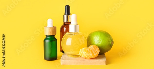 Obraz Bottles of citrus essential oil on yellow background