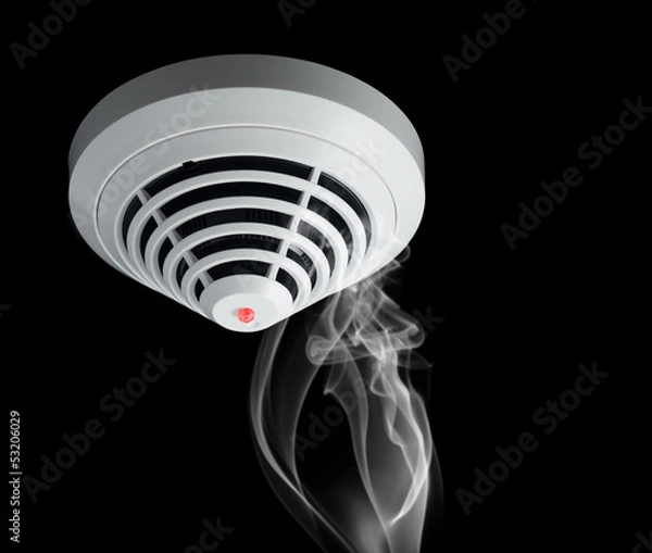 Fototapeta Smoke around fire detector on black background.