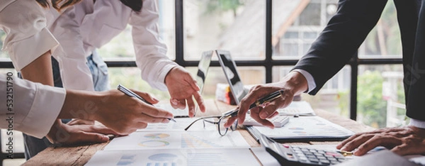 Fototapeta Young colleagues discussing business and price chart analyzes business people on the table great in modern coworking office teamwork concept. Calculate personal tax for customers