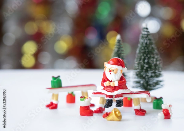 Fototapeta Santa Claus reclining on a red pew in front of the Christmas tree in anticipation of the funny and happiness festival. 