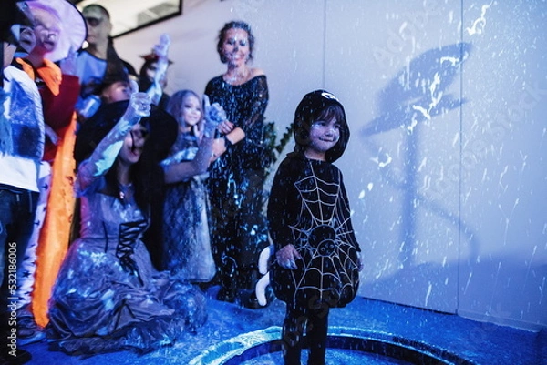 Obraz Children's disco. Children have fun at the soap bubble show. Fluorescent paint on the face in ultraviolet. Film noise. Diffuse focus. Halloween party