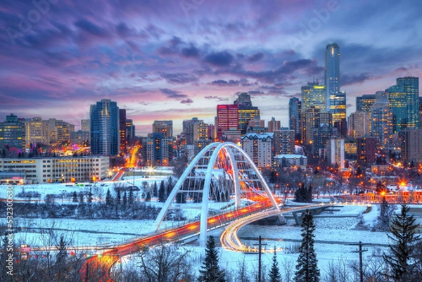 Fototapeta Light trails from rush hour traffic light up Walterdale Bridge in Edmonton, Canada, on a sunset winter night.