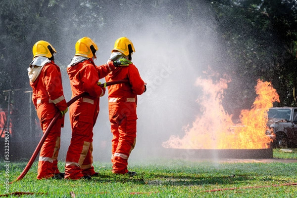 Fototapeta Firefighters safety using twirl water fog type fire extinguisher to fighting with fire from oil and gas to control fire not to spread out Firefighter stop this accident and safety concept.