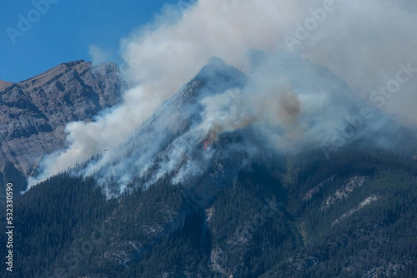 Fototapeta Forest wildfire and smoke on the side of a mountain