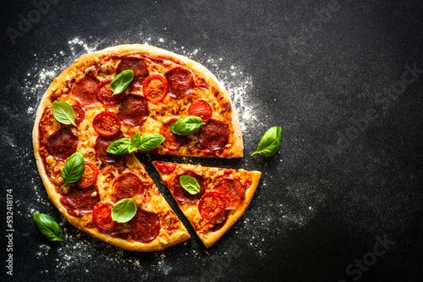 Fototapeta Pizza on black background. Traditional italian pizza with salami cheese, tomatoes and basil. Top view with copy space.