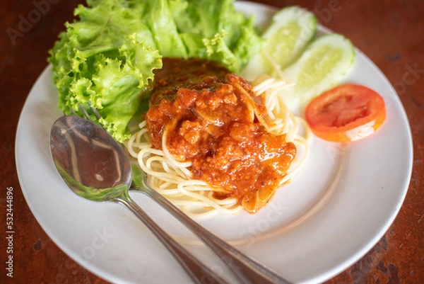Fototapeta Spaghetti Pasta and tomato sauce Garlic and spices with cheese and fork in a lettuce platter