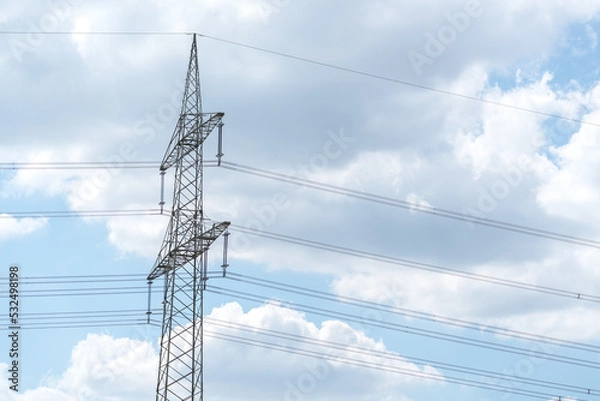 Fototapeta Electricity pylon for over land power transmission of high voltage in front of blue sky