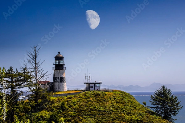 Fototapeta large moon over lighthouse