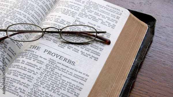 Fototapeta An old King James Bible on a table open to the book of Proverbs.
