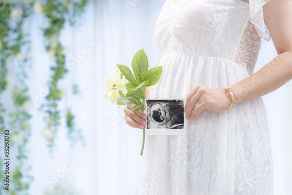 Fototapeta マタニティドレスでエコー写真を持つ妊婦 室内（本物の臨月妊婦さんを撮影）