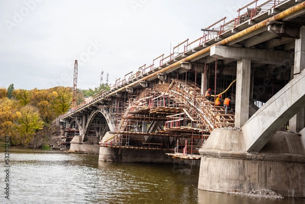 Fototapeta Scaffolding with a support system of beams at the reconstruction of the bridge.