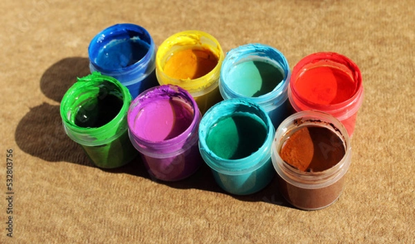 Fototapeta Acrylic paints in jars. Photo of opened pots with different colors of paint 