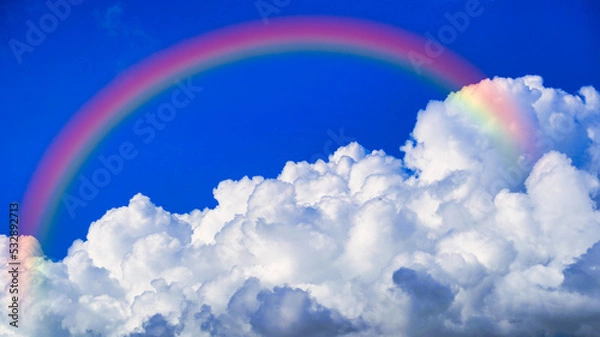Fototapeta 青空に浮かぶ白い雲にかかる虹