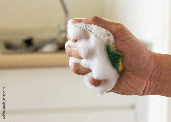 Fototapeta Sponge in squeeze hand with dishwashing liquid