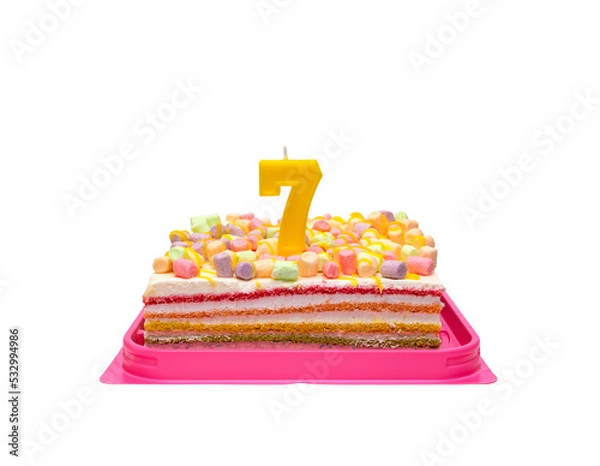 Obraz multi-colored rainbow cake in a transparent box with a red bow. Birthday cake with candle number 7 isolated on white background.