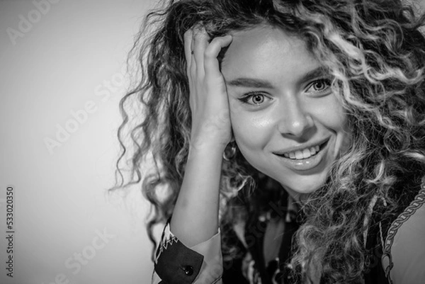 Fototapeta Portrait of Beautiful Young Woman with Curly Hair. Cute Girl Looking At Camera And Smiling 
