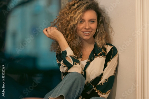 Fototapeta Portrait of Beautiful Young Woman with Curly Hair. Cute Girl Looking At Camera And Smiling 