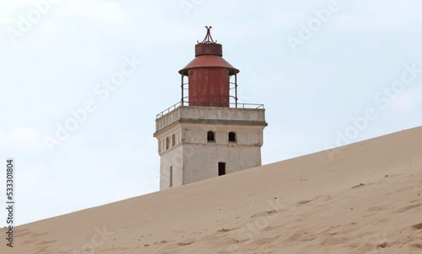 Fototapeta Lokken, Denmark - August 24, 2022: Rubjerg Knude Lighthouse, Denmark, that was put out of action because of the sandstorms, is now a big tourist attraction. Partial because of the huge sand dunes.