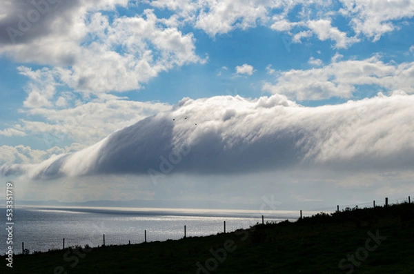 Fototapeta Dramatic clouds near the Mull of Kintyre Scotland with the coast of Northern Ireland in the distance