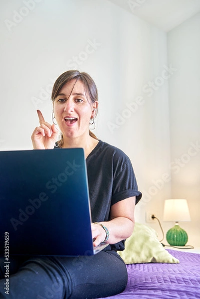 Fototapeta Vertical shot of Caucasian woman with getting solution face looking at computer from bedroom
