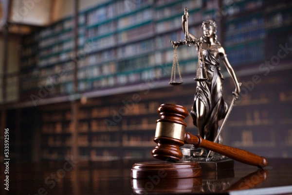 Fototapeta Law theme. Themis statue, scale and judge gavel in the law faculty library.