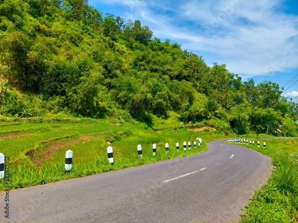 Obraz a highway under the hills against the background of a bright blue sky